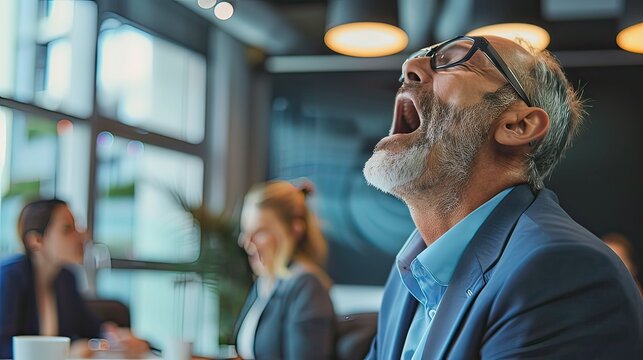 Middle-aged white business professional stifling a yawn while listening to a presentation in a boardroom. 