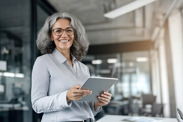Fototapeta premium Mature woman with a tablet and a smile