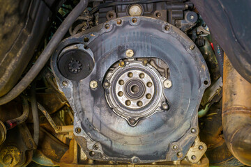 View of the rear crankshaft oil seal on back engine is dirty.The mechanic is repairing the engine.