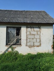 boarded up window, wreckage of an old destroyed wooden house, demolition of a private sector
