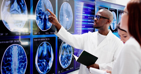 Doctors In Clinic Looking At Brain MRI Scan