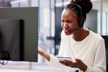 Worried African American businesswoman in office uses headset
