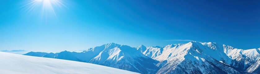 Obraz premium Breathtaking winter landscape showcasing majestic snow-covered mountains under a clear blue sky with shining sunlight.