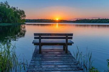 Naklejka premium Tranquil summer sunset over a lake with wooden dock and bench, calm water in northern Canada.