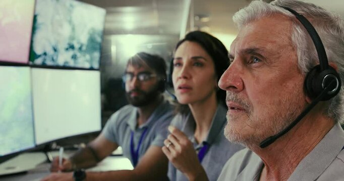 Group, engineers and launch of satellite in control room with headset, communication and ground support of flight. People, sonar capsule and project with rocket system for government security of cctv