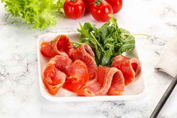 Sliced salmon with fresh arugula