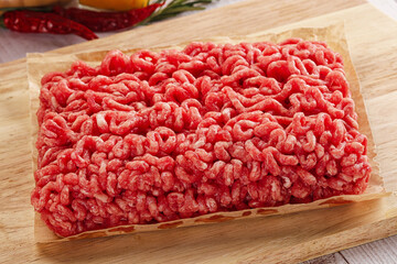 Raw minced beef meat over board