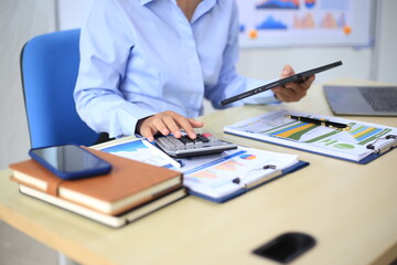 Employees are working at their desks analyzing statistical data to identify trends in the company's revenue.