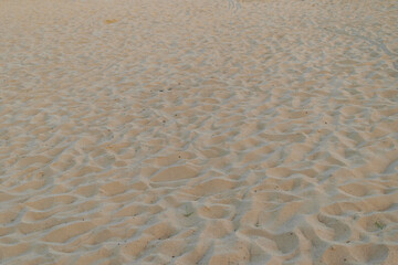 Suchy beżowy piasek na plaży z bliska, wakacyjny motyw