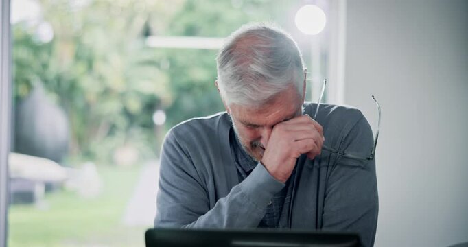 Senior, frustrated man and laptop with documents for financial crisis, payment or debt at home. Mature, male person or struggle with paperwork for finance, debit order or mandate on computer at house
