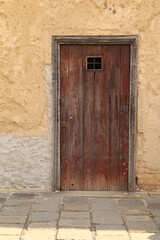 small, rectangular wooden door in a wall. 