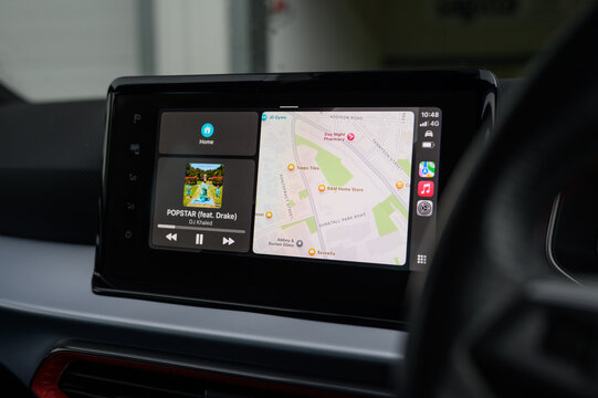 Apple Maps light mode on CarPlay screen with music controls