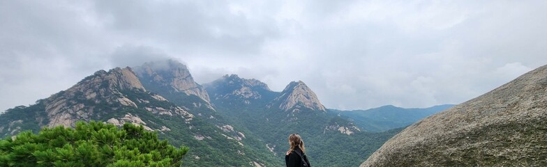 girl looks at fog in rainy weather on the Bukhansan Mountain in Seoul. nature at Bukhansan National Park South Korea