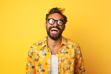 Smiling man with sunglasses and colorful floral shirt against yellow background – Concept for summer, fashion, joy of life