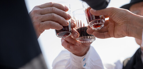 Men in folk costumes toasting with wine. The consumption of red wine is typical in Hungarian rural culture.