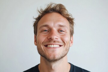 Fototapeta premium Handsome young man with blue eyes smiling on white background