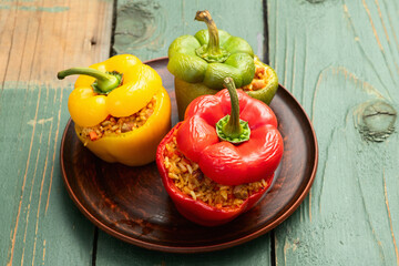 Baked stuffed pepper ( paprika ) with rice , carrot and meat . Top view on rustic background