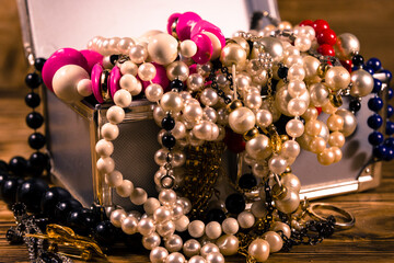 Aluminium case full of different jewelry on wooden table