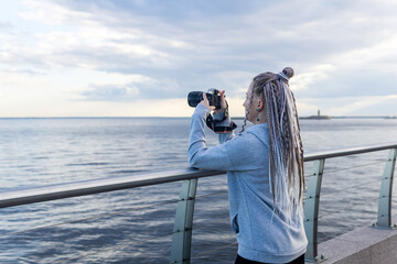 Obraz premium female tourist takes photo on embankment