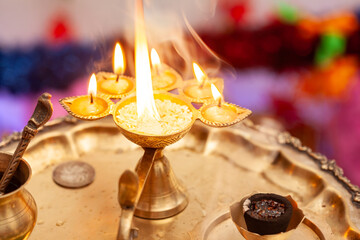 Close-up of a Puja or Arti thali with a brass oil lamp and incense stick for worshiping the Hindu...