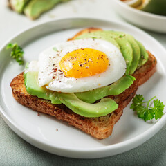 Toasted bread with avocado and fried egg. Delicious and healthy sandwich. Cooking and culinary