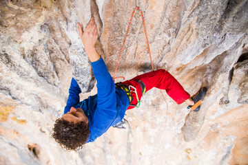 A rock climber ascends to the summit via a difficult route.