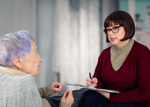 Ensuring final wishes: Notary carefully documents elderly woman's animated instructions during important home consultation.