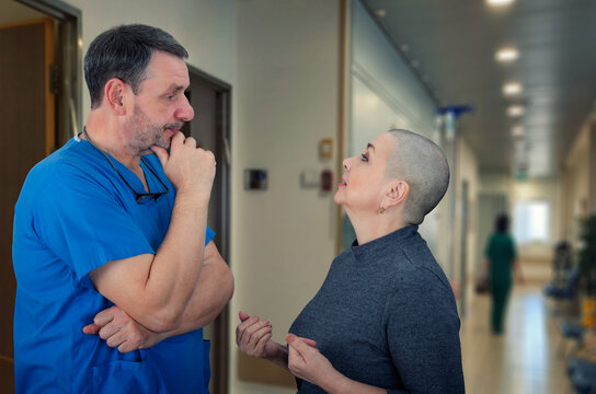 Touching moment as surgeon reconnects with cancer survivor, exchanging health updates in busy medical facility corridor.