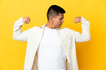 Young Ecuadorian man isolated on yellow background doing strong gesture