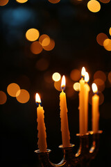 Burning candles standing on vintage candle holder. Close up of Menorah against dark blurred background