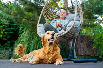 Young female cancer patient relaxing in hanging chair on the patio with her emotional support...