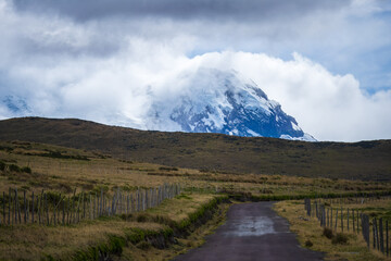 Fototapeta premium The snow-capped volcano Antisana located between the provinces of PIchincha and Napo in Ecuador with blue sky and white clouds. Landscape in Ecuador 