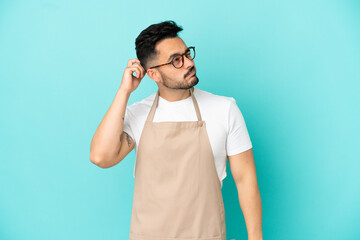 Restaurant waiter caucasian man isolated on blue background having doubts and with confuse face...