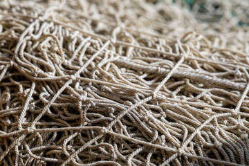 Close-up of layers of natural rope fishing net. Texture of an old fishing net.