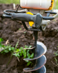 Tool hand-held soil hole drilling machine for prepare the soil for planting shrubs or trees, or for construction work.
