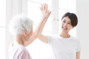 ヨガをする若い女性とシニア女性　健康イメージ