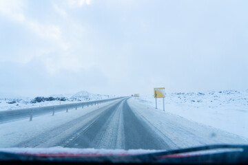 Icy and snowy road seen from inside a car