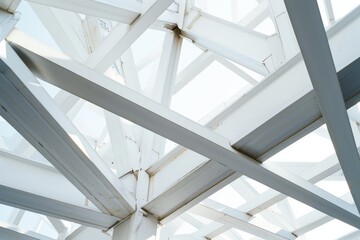 Obraz premium Architectural detail of overlapping white steel beams, creating a geometric pattern against a bright sky, evoking modernity and structural elegance.