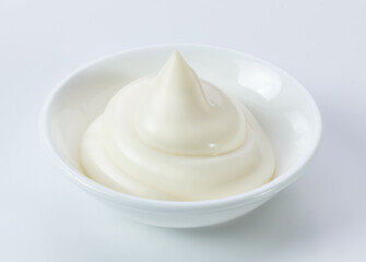 mayonnaise in a ceramic dish isolated light color background.