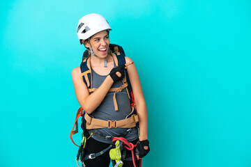Young Italian rock-climber woman isolated on blue background pointing finger to the side and presenting a product
