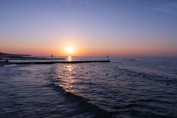 Serene sunset at the shoreline in Kolobrzeg, Kołobrzeg