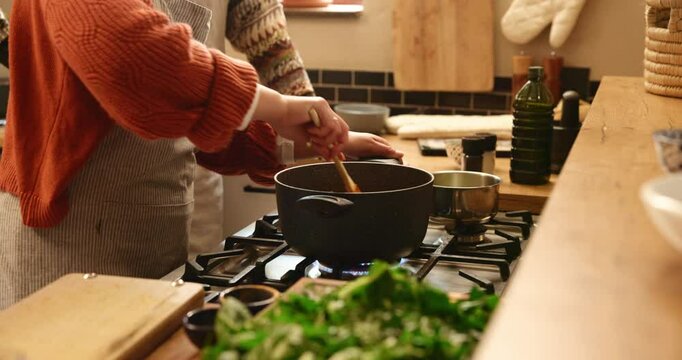 Pot, cooking and hands of couple in kitchen together with teamwork on food recipe, lunch and bonding in home. Diet, wellness and man helping woman in apartment with partnership, meal prep and love