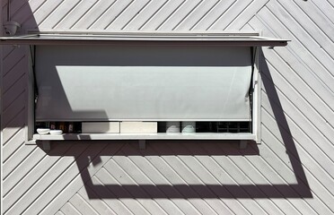 Beach bar, closed hatch, beautiful shade cast by the sun, black and White picture