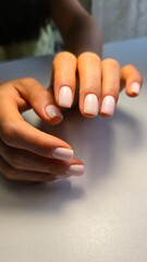 Naklejka premium The beauty of the natural nails. Perfect clean manicure. New trendy nail arts on young women hand. Beautiful nail polish in hand