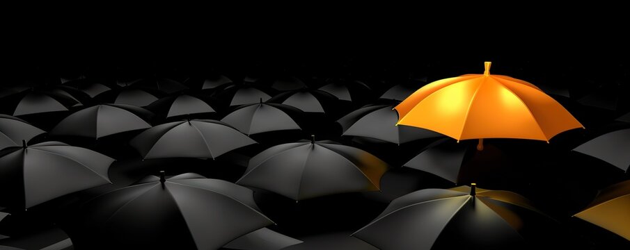 A single orange umbrella stands out from a sea of black umbrellas. A concept of individuality and uniqueness.