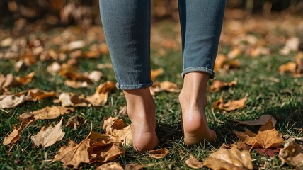 barefoot womens heel walking down the grass, dry autumn leaves