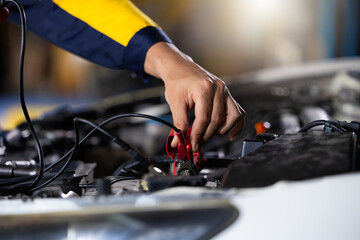 Battery inspection. Battery Capacity Tester Voltmeter. Closeup hand man professional mechanic repairs car working in garage. Car maintenance and auto service garage concept