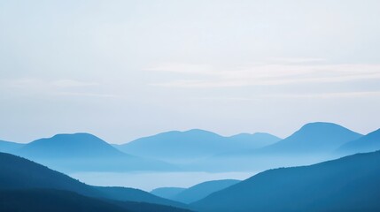 Fototapeta premium Beautiful misty blue mountains at dawn. Serene landscape with layers of hills fading into the distance under a calm sky.