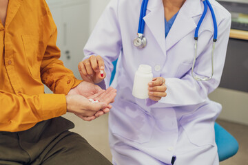 A female doctor performs a check for an enlarged prostate, evaluating male health issues such as...