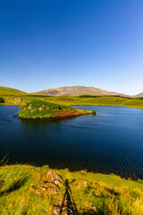 Obraz premium Snowdon or Yr Wyddfa mountain summit, Snowdonia or Eryri National Park lake and island in foreground wide angle.
